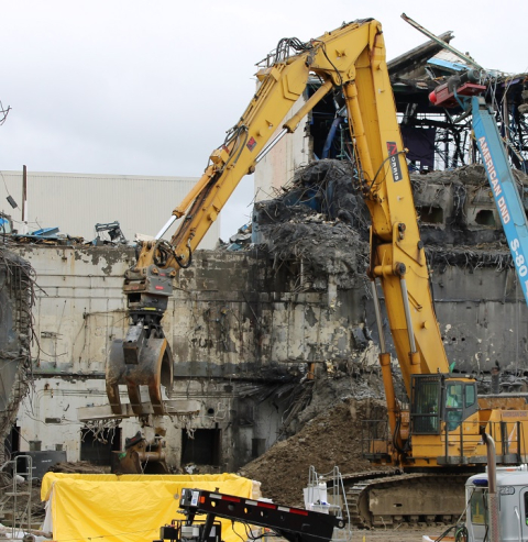 Large, yellow, construction machinery removing materials 