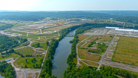 An aerial view of a river with large facility buildings on either side of it