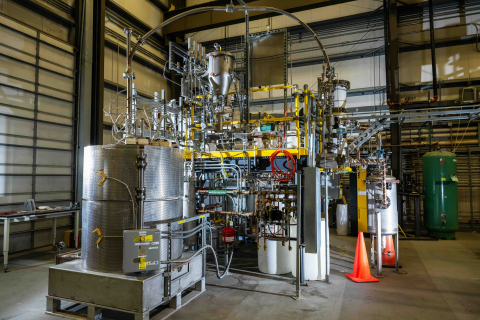 A large pumping system with lots of metal tubes and wires throughout, sitting inside a facility building