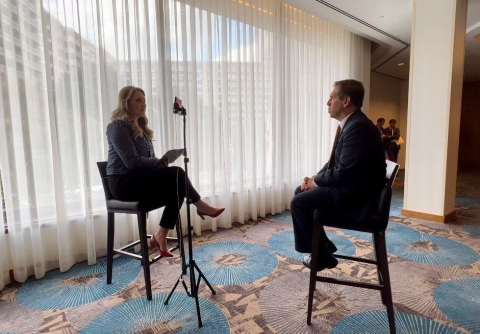 Two people sit in chairs and talk to each other during an interview
