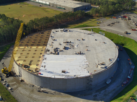An aerial video of a large circular facility building