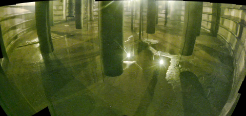 Inside view of a tank with lots of liquid inside and poles coming out of the ground