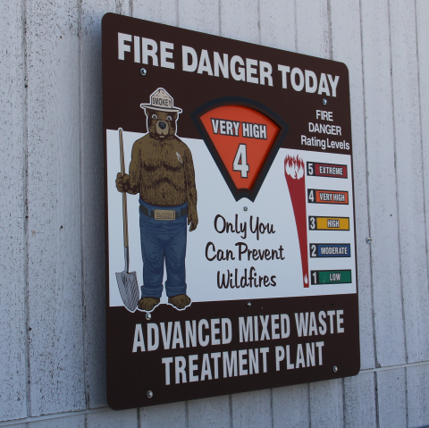 A fire safety plaque on the wall with a brown bear on it