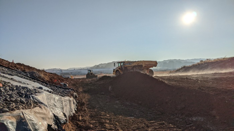 A dump truck driving over contaminated soil requiring removal at the East Tennessee Technology Park.