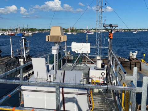 Radar equipment atop a floating barge in a large body of water. 