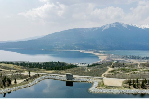 Aerial view of the Mount Elbert pumped storage hydropower facility in Lake County, Colorado, on the shore of Twin Lakes with mountains in the background.