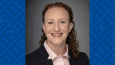Portrait of a smiling woman dressed formally.