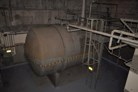 A large, rusted, underground tank