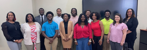 A group of college students dressed professionally pose for a picture