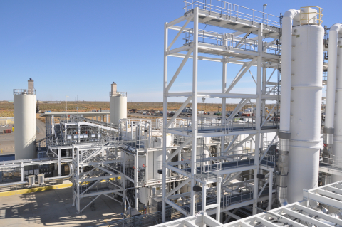 A large white facility plant with lots of tubes, structures and tanks within it