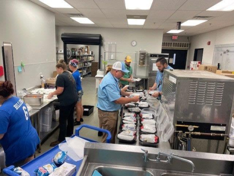A group of employees making box lunch meals for hurricane victims