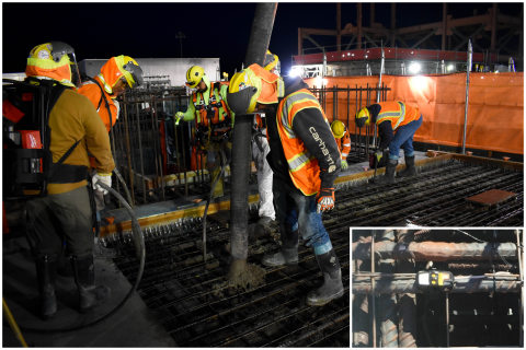 A group of workers in safety gear works on placing concrete