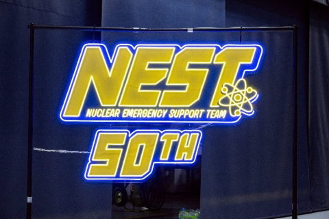 A lit-up sign with the NEST logo, the words Nuclear Emergency Support Team, and 50th.