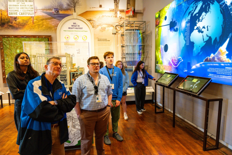 A group of college students and professors touring a museum