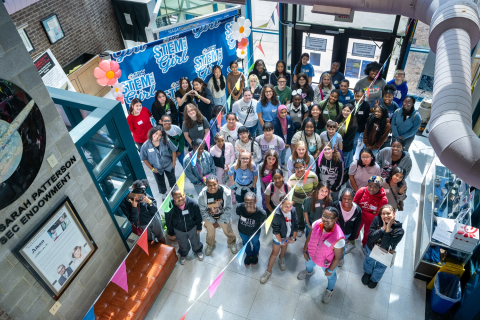 An overhead picture of a group of young girls inside a laboratory