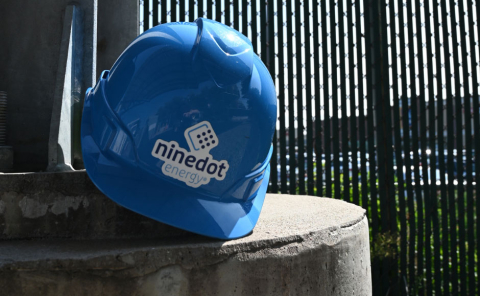 Blue helmet with the Ninedot Energy logo resting on a post