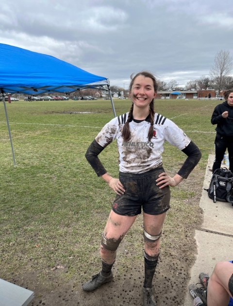 Emilie Lozier in a muddy rugby uniform .