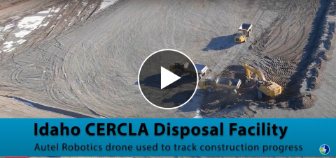 An aerial view taken by a drone of a large gravel area with work vehicles