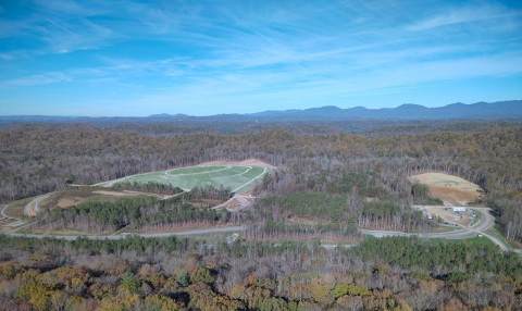 An aerial view of a wooded area with a few clear spots of land