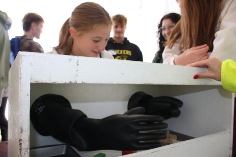 A young girl puts her arms and hand into a glovebox