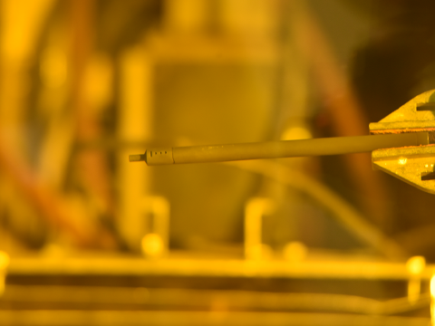 SiGA rodlet held by a metal clamp in a hot cell