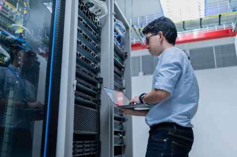 Person standing in front of server racks