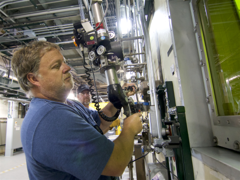 An employee in a blue shirt working with a machine