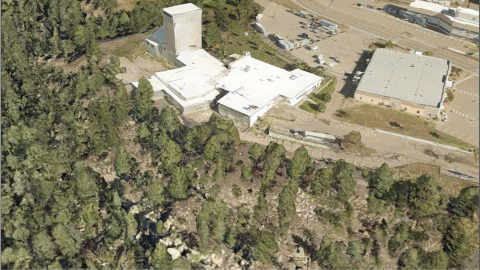 An aerial view of the Los Alamos Ion Beam Facility surrounded by trees