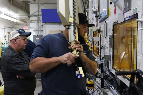 An employee operates a hot cell machine