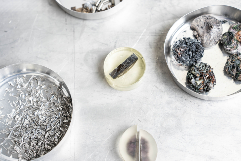 close-up of silver and gray alloys in round petri dishes