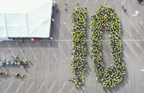 A large group of employees spelling out the number "10" with their bodies