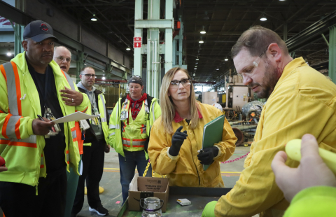 A group of employees in safety gear participate in a training