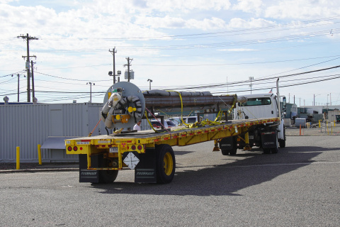 A pump being hauled on the back of a truck
