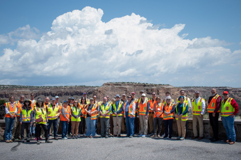 A large group of people pose for a group photo outside