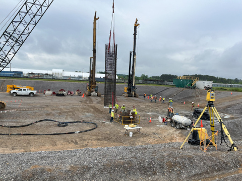 A construction site, workers build the foundation of a new facility building