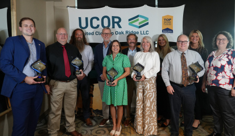 A group picture at an awards ceremony with people smiling while holding awards