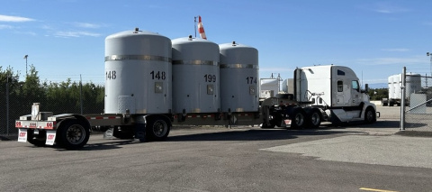 A tractor trailer truck with three large tanks on the back of it