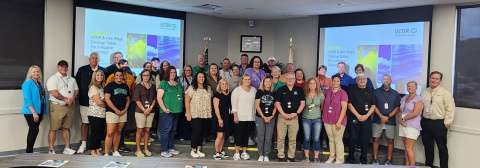 A large group photo of educators at the front of a room