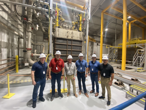 A group of individuals pose for a picture inside a facility building