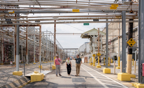 Three employees walking outside of facility buildings at the Savannah River Site