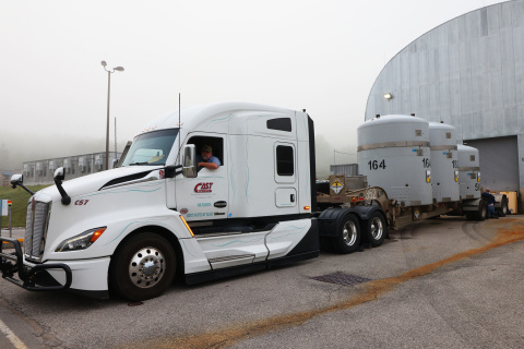 A large white truck hauling three large tanks on the back