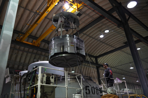 An employee using a large machine to load waste