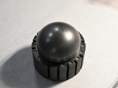 Black spherical fuel pebble on white table