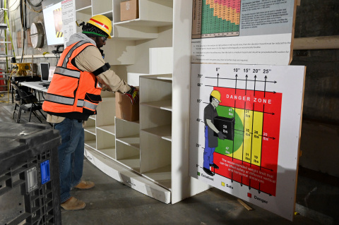 A man in protective gear using a health monitor at the Hanford site
