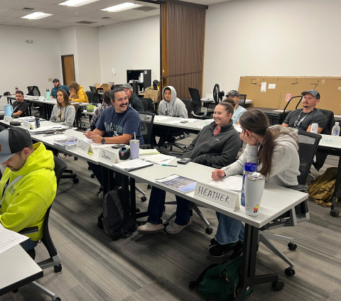 Students in a chemical operator class sitting at three rows of long tables in classroom