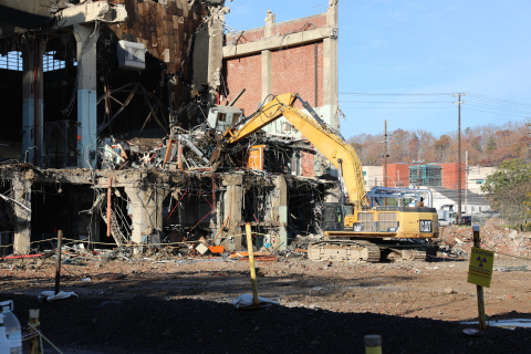 A construction vehicle demolishing a building at the Oak Ridge site