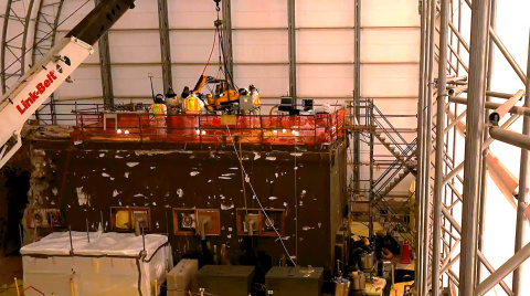Employees inside a facility building working on a hot cell at the Oak Ridge site