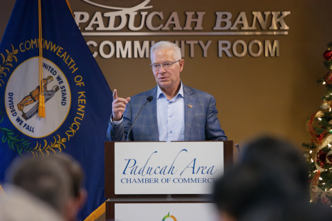 EM's Assistant Secretary stands behind a podium and speaks to a crowd