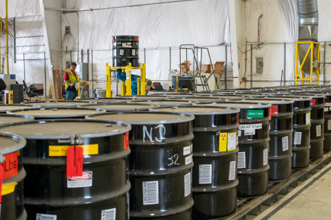 Rows of waste drums on a conveyer belt at the Idaho site