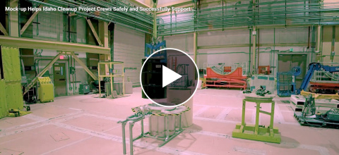 A still with a play button from a video showing remote machines handling waste at the Idaho site